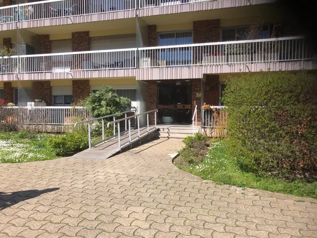 Porte d'entrée vitrée de l'immeuble avec le numéro 68 et l'interphone