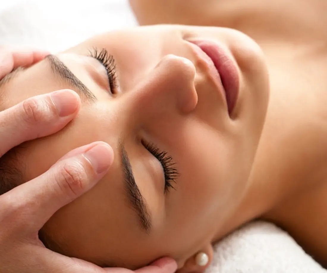 Massage du visage pratiqué pendant une séance de réflexologie